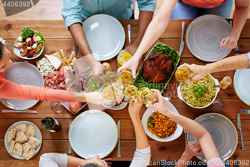 Image of people having dinner and clinking wine glasses