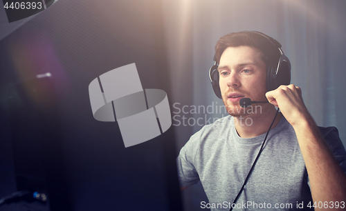 Image of man in headset playing computer video game at home