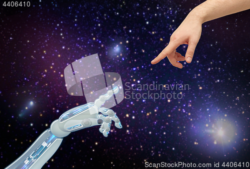 Image of human and robot hands over space background