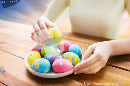 Image of close up of woman hands with colored easter eggs