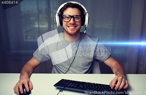 Image of man in headset playing computer video game at home