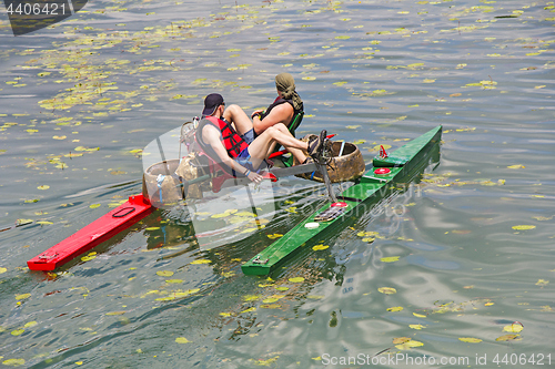 Image of Two man ride with floating pedal bicycle boats across the lake