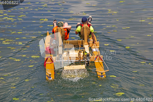 Image of Two man ride with floating pedal bicycle boats across the lake