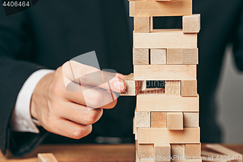 Image of Man and wooden cubes on table. Management concept