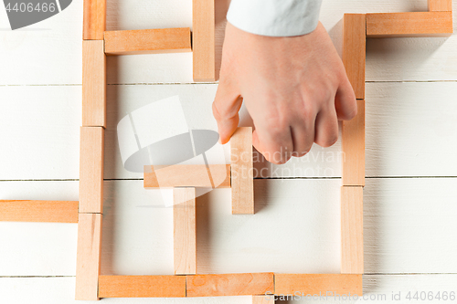 Image of Man and wooden cubes on table. Management concept