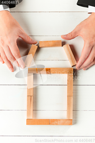 Image of Man and wooden cubes on table. Management concept