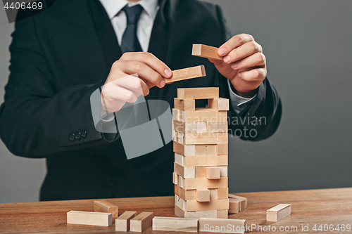 Image of Man and wooden cubes on table. Management concept