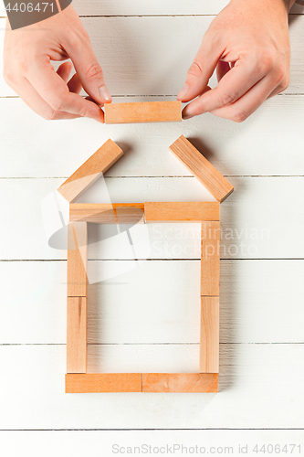 Image of Man and wooden cubes on table. Management concept