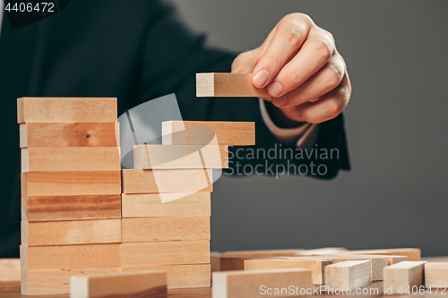 Image of Man and wooden cubes on table. Management concept