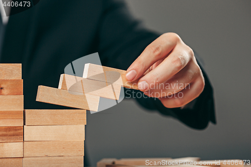 Image of Man and wooden cubes on table. Management concept