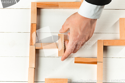 Image of Man and wooden cubes on table. Management concept