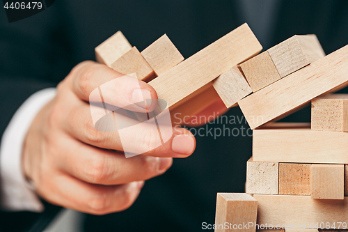 Image of Man and wooden cubes on table. Management concept