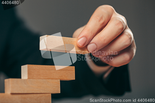 Image of Man and wooden cubes on table. Management concept