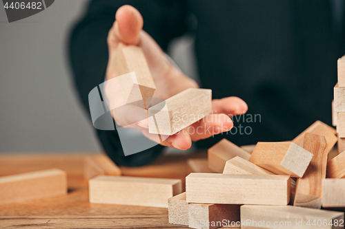 Image of Man and wooden cubes on table. Management concept