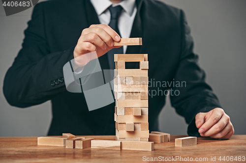 Image of Man and wooden cubes on table. Management concept