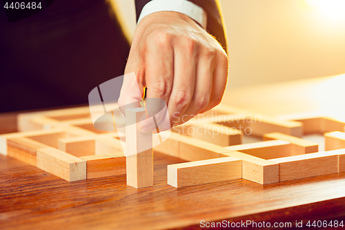 Image of Man and wooden cubes on table. Management concept