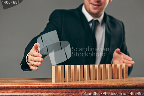 Image of Man and wooden cubes on table. Management concept