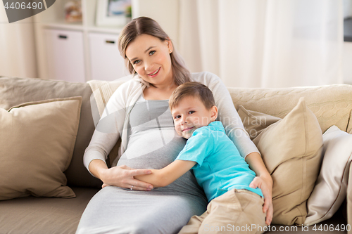 Image of happy pregnant mother and son hugging at home