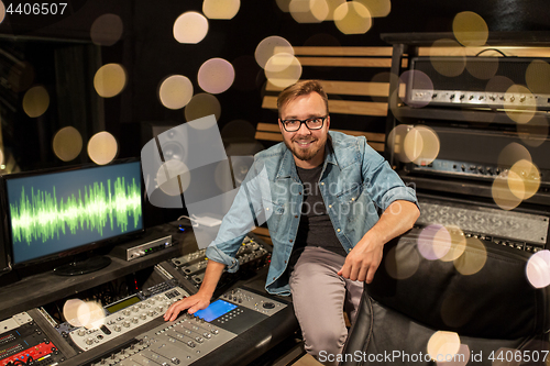 Image of man at mixing console in music recording studio