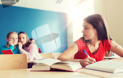 Image of students gossiping behind classmate back at school