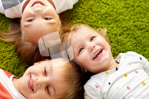 Image of happy little kids lying on floor or carpet