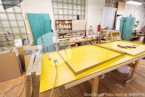 Image of glue gun and frame on workbench at workshop