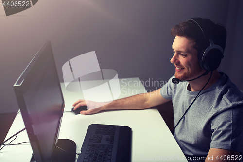 Image of man in headset playing computer video game at home