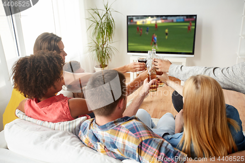 Image of friends clinking beer and watching soccer game