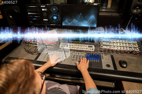 Image of man at mixing console in music recording studio