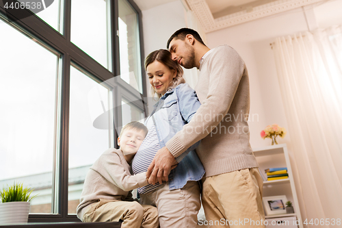 Image of happy family with pregnant mother at home