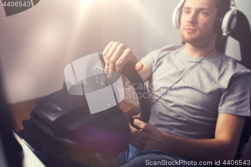 Image of close up of man playing car racing video game