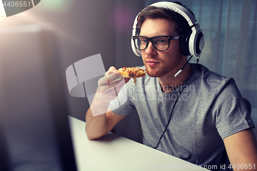 Image of man in headset playing computer video game at home