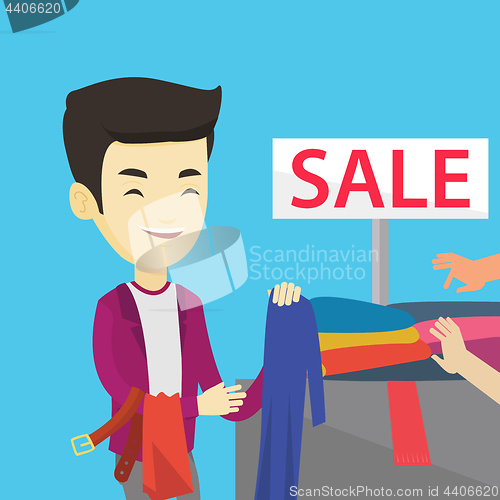 Image of Young man choosing clothes in shop on sale.