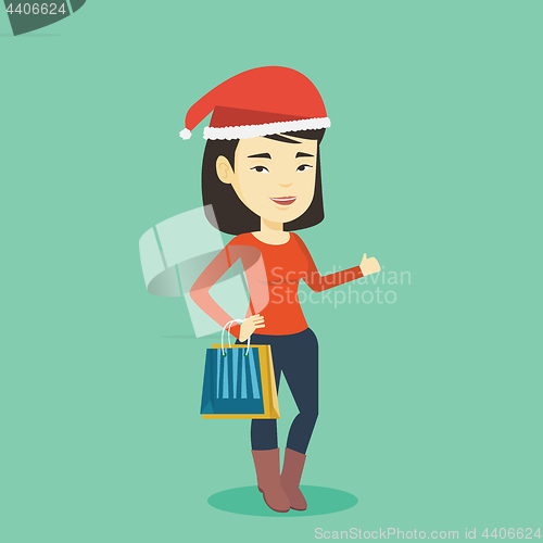 Image of Woman in santa hat shopping for christmas gifts.