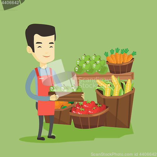 Image of Supermarket worker with box full of apples.