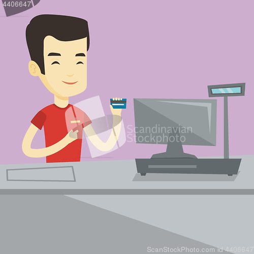 Image of Cashier holding credit card at the checkout.