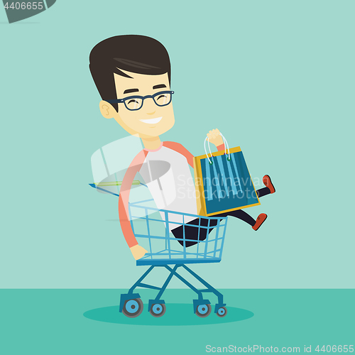 Image of Happy man riding by shopping trolley.