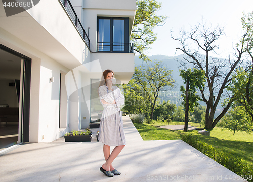 Image of woman in a bathrobe enjoying morning coffee