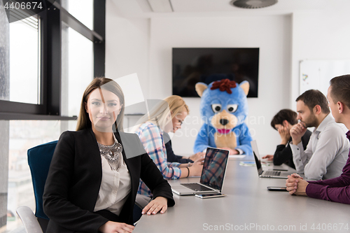 Image of boss dresed as bear having fun with business people in trendy of