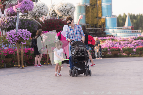 Image of mother and daughter walking in flower garden