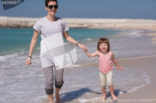Image of mother and daughter running on the beach