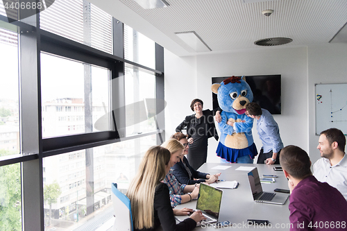 Image of boss dresed as bear having fun with business people in trendy of