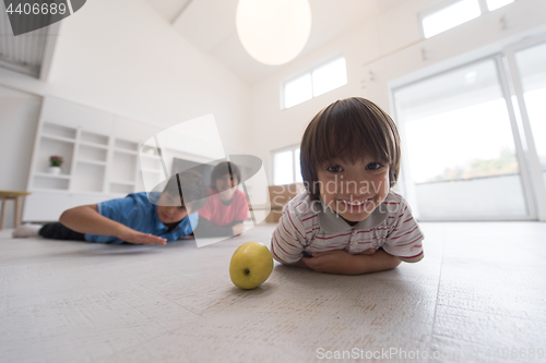 Image of boys having fun with an apple on the floor