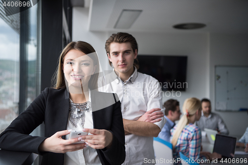 Image of Elegant Woman Using Mobile Phone by window in office building