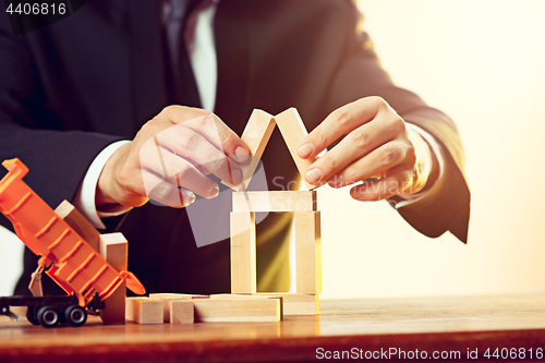 Image of Man and wooden cubes on table. Management concept