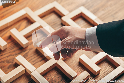 Image of Man and wooden cubes on table. Management concept