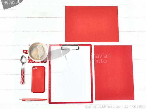 Image of Office table desk with set of colorful supplies, white blank note pad, cup, pen on white background.