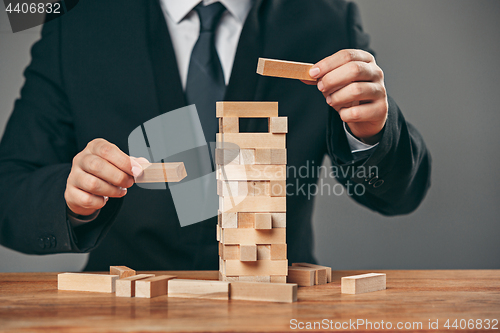 Image of Man and wooden cubes on table. Management concept