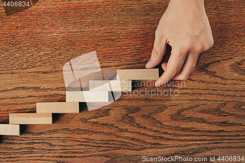 Image of Man and wooden cubes on table. Management and marketing concepts