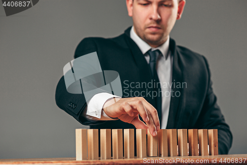 Image of Man and wooden cubes on table. Management concept